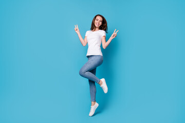 Fototapeta na wymiar Full length body size view of her she nice attractive pretty skinny cheerful cheery girl jumping showing double v-sign having fun isolated bright vivid shine vibrant blue color background