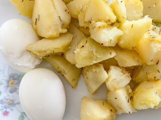 Uova sode con patate lesse ripassate in padella con peperoncino e origano 