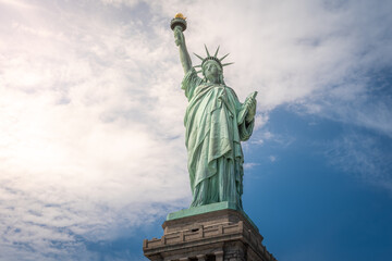 Shot of the Statue of Liberty in New York City, Usa. The shot is taken during a beautiful sunny day with a blue sky and white clouds in the background