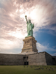 Shot of the Statue of Liberty in New York City, Usa. The shot is taken during a beautiful sunny day with a blue sky and white clouds in the background