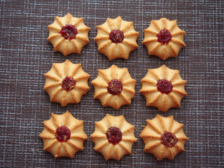 A few pieces of kurabye cookies lie on the brown tablecloth.