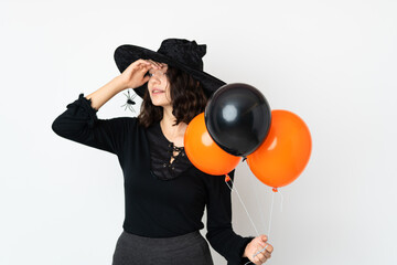 Young witch holding black and orange air balloons has realized something and intending the solution