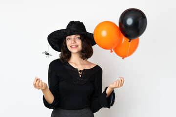 Young witch holding black and orange air balloons making money gesture