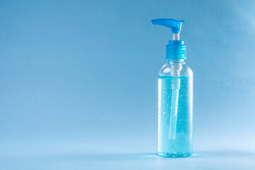Bottle sanitizer gel alcohol desinfectant for hands in neutral background blue