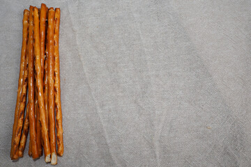 brown straight salty pretzels on beige fabric top view