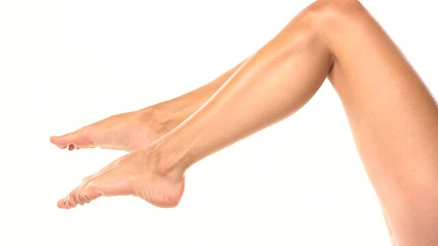 nicely groomed female legs moving on a white background