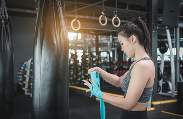 Fototapeta na wymiar Portrait beauty sport woman wear sportwear posing under exercise with fighting fitness equipment at gym ,she exercise for strong ,make muscle ,protecting basic and good healthy..