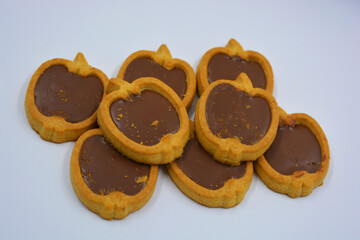 Fresh delicious crunchy shortbread cookies with nutty, chocolate filling inside. Apple-shaped cookies with brown filling located on a white matte background.