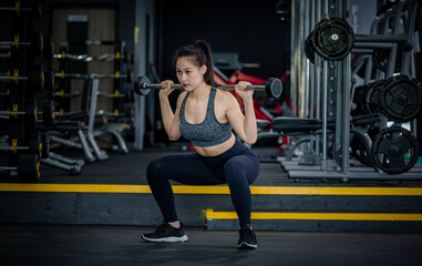 Fototapeta na wymiar Portrait beauty sport woman wear sportwear posing under exercise with fitness equipment at gym ,she exercise for strong ,make muscle and good healthy