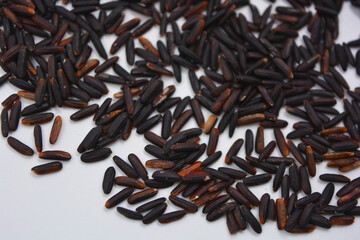 Useful black long unpolished wild rice sprinkled on a white plate. Healthy food, healthy cereals for every day is natural rice.