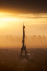 A misty sunset around the Eiffel Tower and the headquarter of La Défense