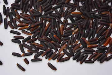 Useful black long unpolished wild rice sprinkled on a white plate. Healthy food, healthy cereals for every day is natural rice.