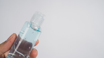 Close up of hand is holding alcohol hand gel on white background.