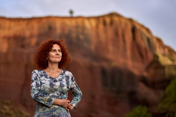 Redhead curly lady at sunset inside an extinct volcano