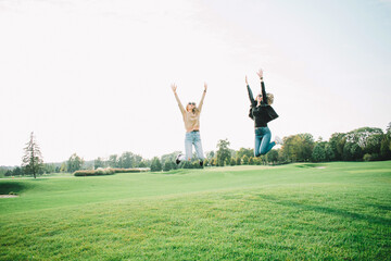 Fototapeta na wymiar Happy girls jumping on the grass