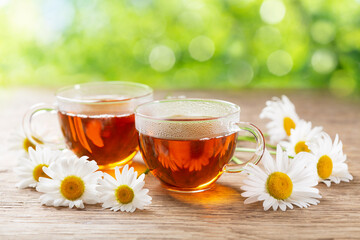 cups of herbal chamomile tea with fresh chamomile flowers