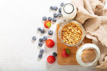 Obraz na płótnie Canvas breakfast with granola, fresh berries and bottle of milk