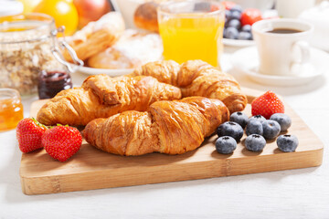 Breakfast with croissants, coffee, juice,  jam, cereals and fresh fruits
