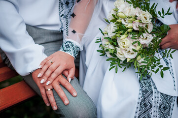 hands of newlyweds with wedding rings and wedding bouquet