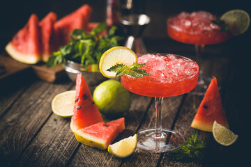 Watermelon frozen cocktail margarita with fresh watermelon, lime and mint on wooden background