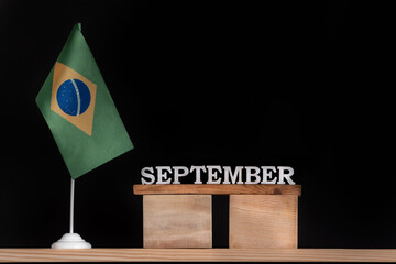 Wooden calendar of September with Brazilian flag on black background. Dates of Brazil in September