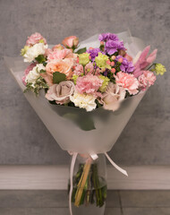 Fresh beautiful flower. Woman holding a big delicate flower bouquet wrapped in paper.
