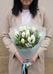 Fresh beautiful flower. Woman holding a big delicate flower bouquet wrapped in paper.