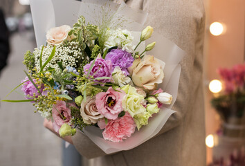 Fresh beautiful flower. Woman holding a big delicate flower bouquet wrapped in paper.