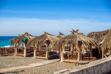 The bungalows are made from palm branches on the blue of the sea