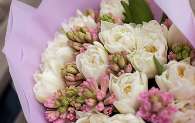 Fresh beautiful flower. Woman holding a big delicate flower bouquet wrapped in paper.