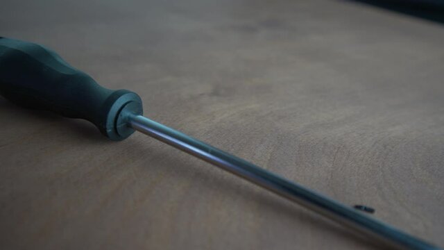 Detail of a screwdriver laid on the wooden table
