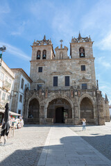 Fototapeta na wymiar Main façade of Braga Cathedral. Entrance gallery with three gothic arches, 15th century, towers and upper storeys, early baroque, front piazza and tourist people