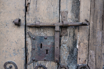 Detail of an old lock of a rusty door and with the old wood