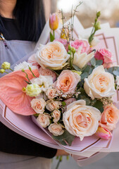 Fresh beautiful flower. Woman holding a big delicate flower bouquet wrapped in paper.