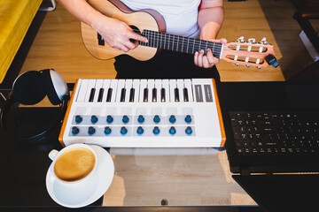 man learning online guitar lesson from internet in living room