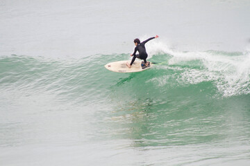 Teenager performing surf maneuver. Father and son sharing surf session in Les Landes France