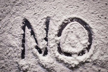 Word No written in white flour powder, concept of saying no to drug abuse and narcotis. Flour representing usage of heavy drugs such as cocaine as people turn to narcotics during hard times of covid