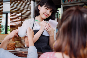 Beautiful asian thai woman coffee shop owner taking order from customer.