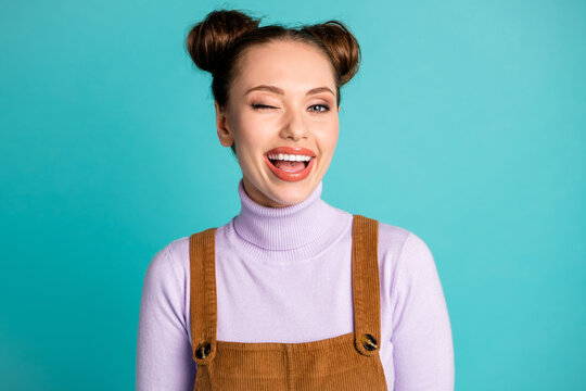 Photo of cheerful friendly nice beaming playful lady girlfriend two buns hairdo glossy lips great amazing time wink one eye open mouth wear fall outfit isolated vivid teal color background