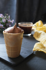 On a dark background, a cup of chocolate ice cream.