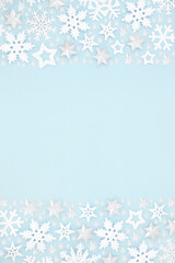 Star & snowflake Christmas background border composition on pastel blue. Winter, Xmas & New Year festive scene for the holiday season. Flat lay, top view, copy space.