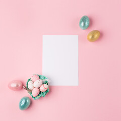 Easter greeting card with colorful easter eggs on pink background. Top view, flat lay with space for your text.