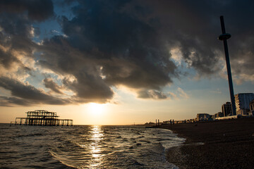 A stormy sky with a derelict pier in the sea and a city in the background
