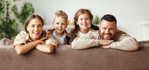 happy family mother father and children at home on couch .