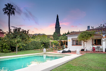 Sunset in a relaxing holiday villa with a swimming pool with tanning ledge,chair pool,umbrella,...