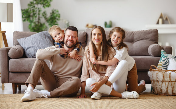 happy family mother father and children at home on couch .