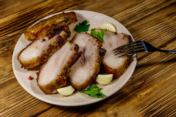 Baked pork belly in a plate on wooden table