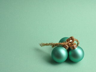 Three turquoise vintage Christmas baubles on a turquoise background with space for your text, seasonal holiday concept