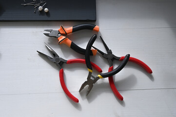 Pliers on lie on white wooden background
