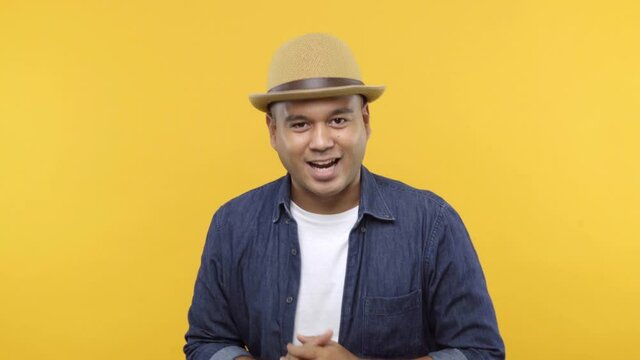 Mc or Explaining man pointing his hand into camera and talk with audience isolated on yellow background.